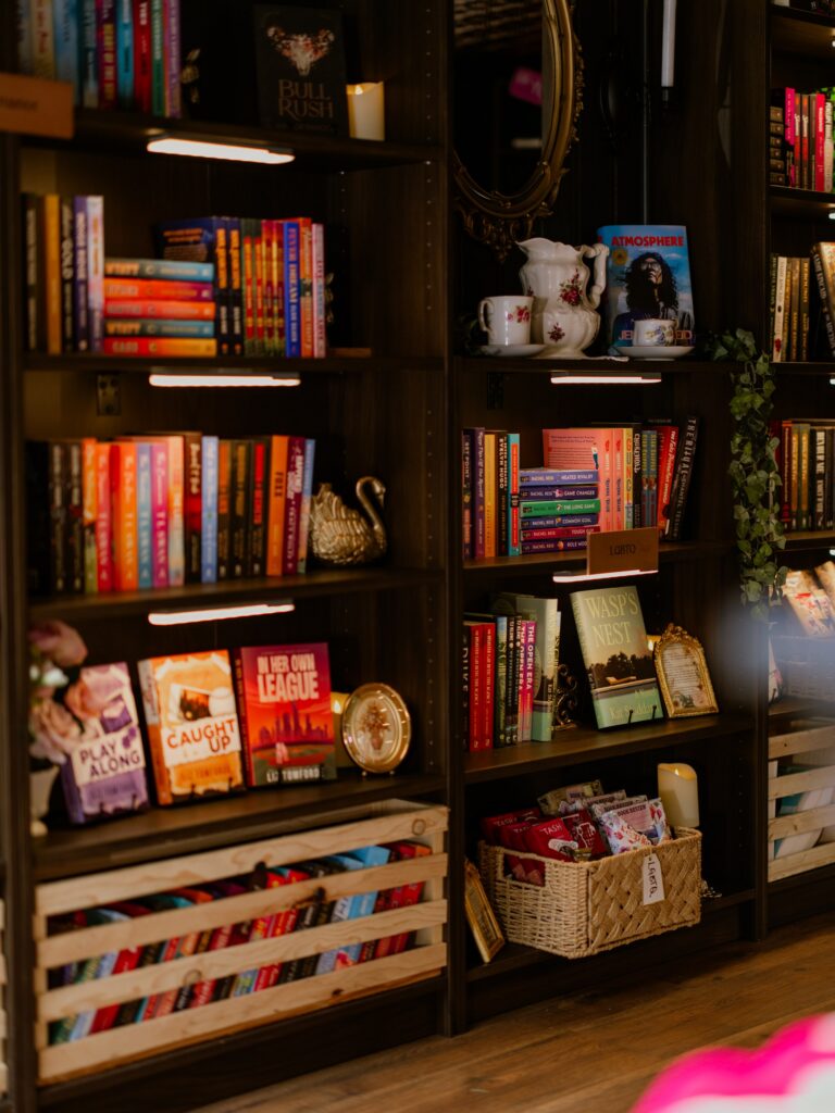 Dark wood bookshelves filled with books line the interior of TBR on Tour, creating the feel of a cozy Victorian library.