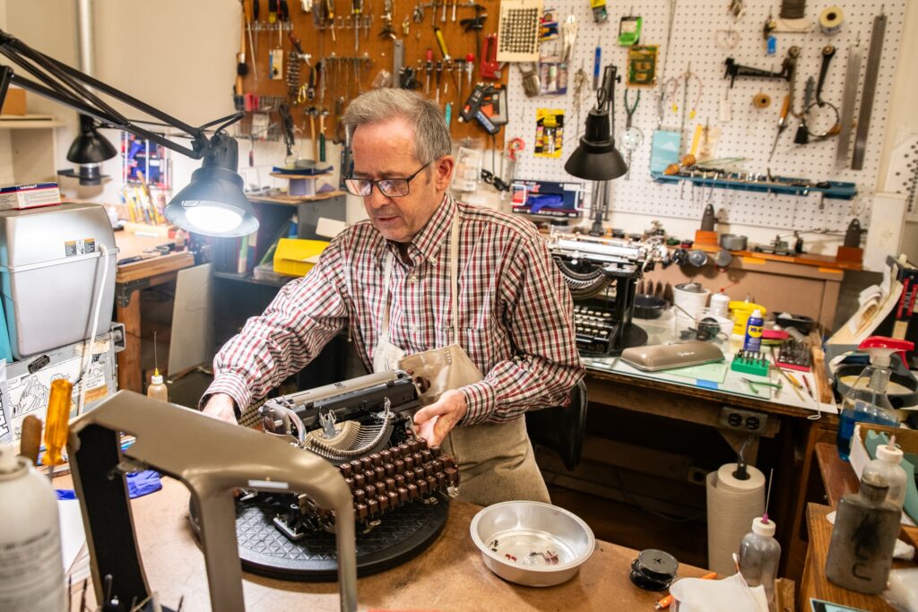 Owner Paul Lundy works on a typewriter at Bremerton Typewriter Co., where repairs make up the majority of the business.