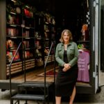 Suzie Vasquez stands at the entrance to TBR on Tour, her mobile bookstore on wheels.
