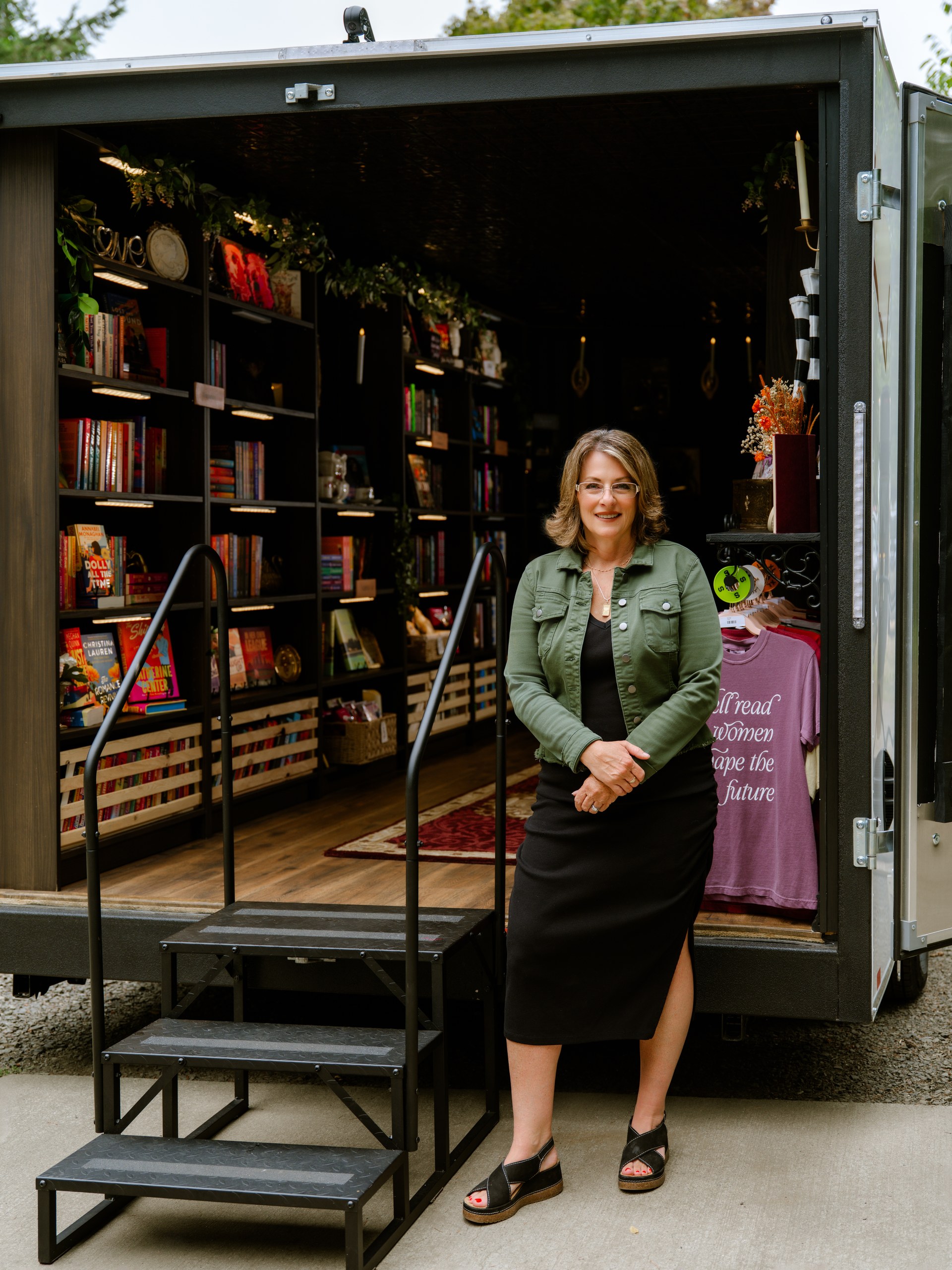 Suzie Vasquez stands at the entrance to TBR on Tour, her mobile bookstore on wheels.
