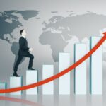 Man climbing bar graph toward global business succ