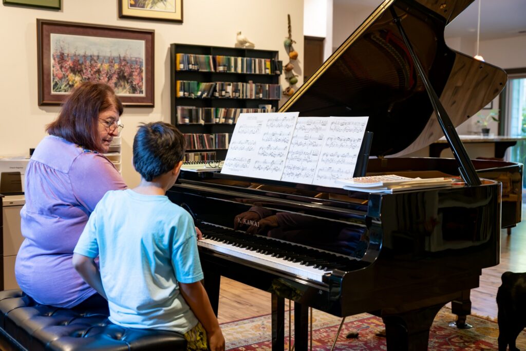 Kastanopolous demonstrates a passage for a student at the piano in her home studio.